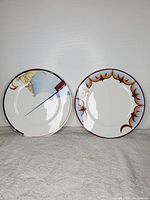 Photo showing two 12-inch porcelain plates side-by-side, pattern #4 on left, pattern #8 on right, on neutral background.