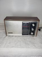 Front view of the vintage Panasonic RE-6451 AM/FM radio showing speaker grill, tuning display, and control knobs.