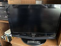 Front view of Samsung 32 inch LCD TV with remote on the stand