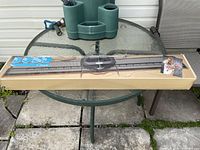 Full view of Bond Classic knitting machine in original cardboard box on outdoor glass table.