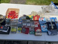 Full view of assorted hardware items on table, including many labeled boxes of nails, screws, and clous.