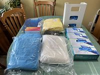 Various packaged blue and yellow hospital gowns, boxes of MedSup blue nitrile gloves, and Yellow Versa gowns.