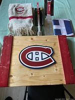 Montreal Canadiens wooden wall sign, scarf, metal BBQ fork, and small flag laid out on table