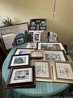 Wide view of assortment of picture frames and boxed Omnitech digital photo frame arranged on table