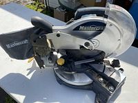Mastercraft 10" compound mitre saw showing blade guard, handle, and dust bag attachment with Mastercraft logo.
