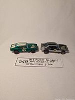 Two vintage Hot Wheels diecast cars placed side by side with handwritten label showing car names and years.