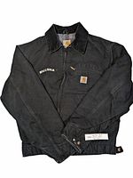 Front view of black Carhartt jacket laid flat showing embroidered Waca Bulk patch on chest and overall exterior condition