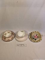 All three Foley fine bone china teacup and saucer sets arranged in a row on a plain light-colored surface.