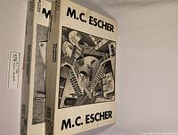 Two puzzle boxes stacked, showing artwork titles and M.C. Escher branding on boxes.