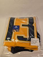 Folded yellow and navy blue Nashville Predators jersey with number 13, visible signature by Nick Bonino on number 3, sealed in plastic with Five Star certification sticker.