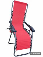 Front view of red gravity chair showing upright seated position, red fabric and black metal frame with armrests