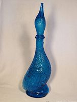 Blue glass duck decanter with textured feather details on body and neck.