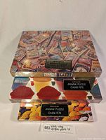 Lot of three vintage sealed Springbok jigsaw puzzles stacked. Top box features vintage matchbox style artwork, middle and bottom boxes show colorful decorative mold images. Boxes are sealed with clear Springbok branding and labels.