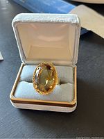 Ring centered in white velvet jewel box, top front view