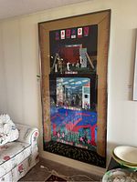 Full view of framed print leaning against wall next to furniture