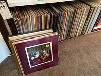 Shelf filled with many vinyl records, several visible titles and genres represented including classical, opera, pop and comedy.