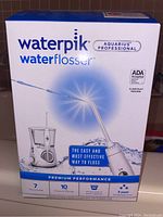 Front view of the Waterpik Aquarius Professional Water Flosser 600 Series box showing product image, brand, and key highlights such as ADA acceptance and 3 year warranty.
