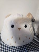 Front view of large white owl stuffed animal showing facial features