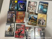 12 DVD movie cases laid out on a flat surface showing original cover artwork and titles.