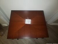 Top view of small wooden square table showing smooth dark wood surface with a subtle gloss.