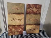 Pair of decorative wall pictures with inspirational words displayed vertically.