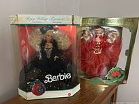 Two vintage Holiday Barbie dolls in original boxes, showing some wear on packaging but dolls sealed inside.