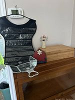 Overall view of the lot showing Umbra jewelry/scarf organizer, a red flower metal business card holder, bamboo box, Willow Tree Angel figurine, and a mirror.