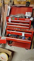 Front view of two-piece red Craftsman tool chest with drawers open and contents visible