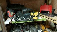 Photo of the Mouse sander, Power Fist hammer drill, and saw with guide on a shelf, showing the wired tools.