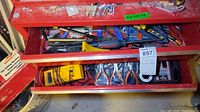 Red toolbox with an assortment of tools including the yellow Huang Chang ohm meter, pliers, clamps, and various hand tools.