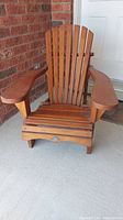Front view of wooden Muskoka chair showing slatted back, armrests, and seat.