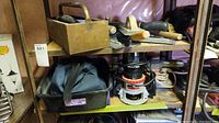 Shelf with metal toolbox containing hand tools, towels beneath, and visible power tools (Black & Decker Sandee, Sears Craftsman router)