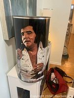 Large cylindrical metal container showing close-up of Elvis Presley image from front view
