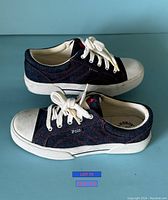 Side view of both shoes showing denim fabric, white rubber toe caps, and laces.