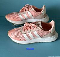 Side profile of Adidas Flashback women's sneakers showing pink mesh upper with white stripes and blush overlays.