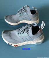 Side view of Adidas NMD Racer women's sneaker showing knit upper and white boost midsole.