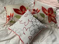 Four throw pillows arranged showing floral patterns and colors to identify tampering, condition, and style.