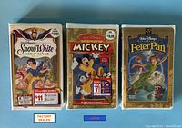 Photo of three factory sealed Walt Disney VHS videos: Snow White and the Seven Dwarfs, The Spirit of Mickey, and Peter Pan (Masterpiece Collection, Limited Edition).