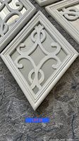 Close-up detail of one vintage mirror with decorative cream wooden frame and atomic-style overlay