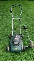 Photo showing both lawn mower and edger on grass