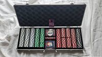 Open poker chip set case showing stacks of blue, green, red, and black chips, cards, dealer button, and dice inside.