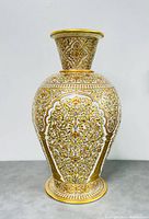 Front view of large gold leaf resin flower vase showing intricate floral and geometric patterns.