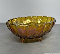 Side view of the amber carnival glass fruit bowl showing scalloped edges and foot design.