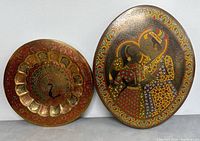 Both etched brass plates side by side showing the peacock and couple motif