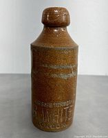 Front view of vintage stoneware bottle showing full height and shape with embossed R. White London marking.