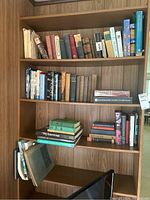 Four shelves of assorted books in various conditions, including classic literature, nursing manuals, and medical dictionaries.