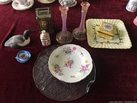 Photo showing the Thomas Lees Hamilton carriage clock, floral trinket box, reproduction Early Worcester Florence plate, candle holders, Royal Crown Derby perfume bottle, and additional decorative items