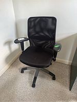 Front and side views of black mesh office chair on wheels with adjustable armrests and height mechanism.