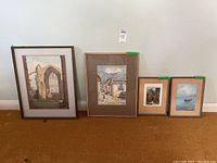 Four framed pieces of art against a white wall, showing different sizes and themes with frames of varying styles and colors.