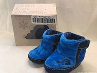Photo of blue fleece booties and the original box.